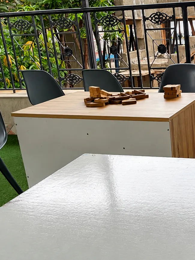 Outdoor balcony recreation space with seating at Pune Centre Hostel