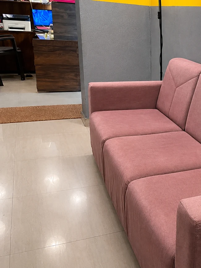 Lobby waiting lounge area with pink couch at Pune Centre Hostel